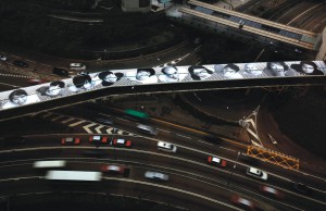 Vehicles drive past a foot bridge decorated with "Inside Out", an artwork by French street artist JR, at Hong Kong's Financial Central District