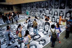 People hold their portraits taken as part of Inside Out art project by French artist JR at Xintiandi area in downtown Shanghai