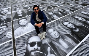 Artist JR poses with his public art installation "Actions" on the Terrace at Somerset House in London